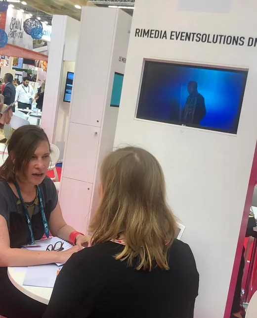 Deux femmes discutent à une exposition